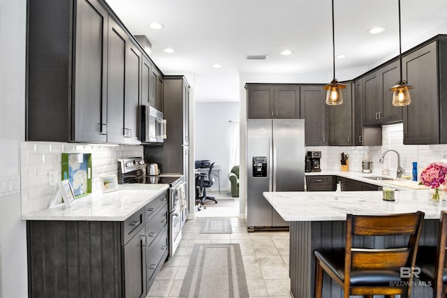 kitchen with appliances with stainless steel finishes, visible vents, a sink, and light stone countertops