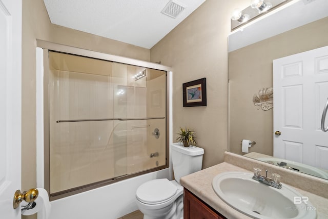 bathroom with combined bath / shower with glass door, visible vents, toilet, and vanity