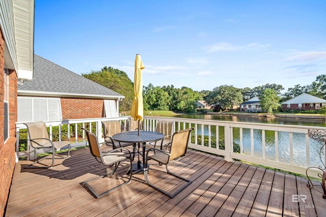 wooden deck featuring outdoor dining area and a water view