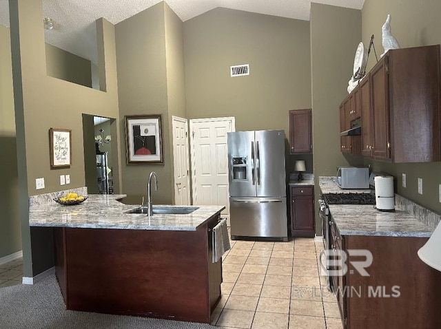 kitchen featuring stainless steel appliances, a sink, high vaulted ceiling, and under cabinet range hood