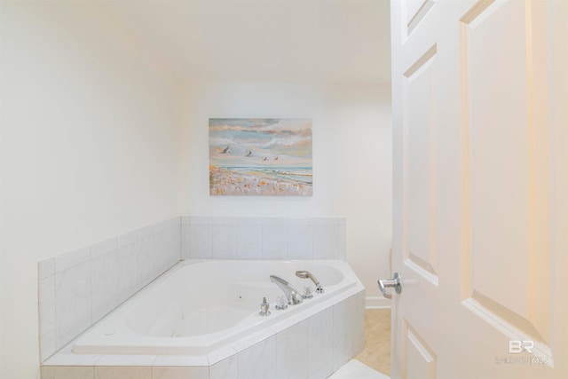 bathroom with tiled tub and tile patterned flooring