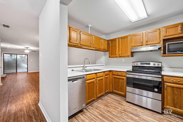 20 Summer Oaks Dr, Daphne, AL 36526 - kitchen featuring stainless steel appliances, under cabinet range hood, light countertops, and light wood-type flooring