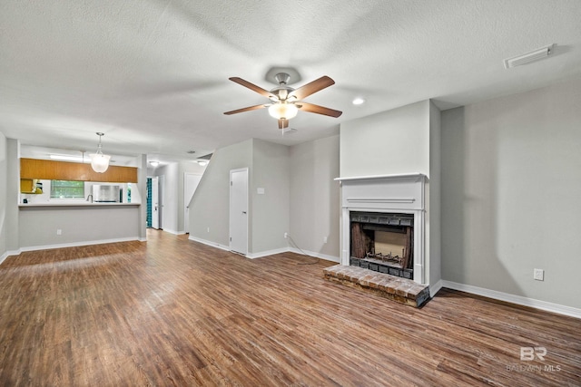 20 Summer Oaks Dr, Daphne, AL 36526 - unfurnished living room with ceiling fan, wood finished floors, a fireplace, and a textured ceiling