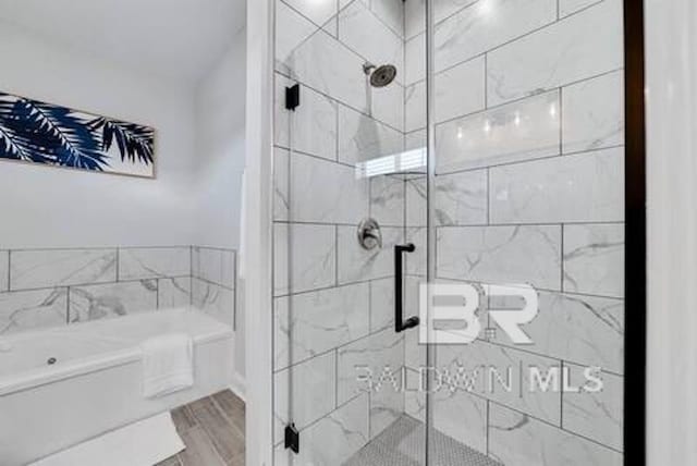 1492 Shell Ln, Gulf Shores, AL 36542 - bathroom with a bath, a stall shower, and wood finished floors