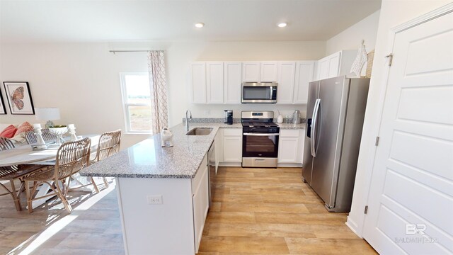 kitchen featuring white cabinets, light stone counters, sink, and appliances with stainless steel finishes