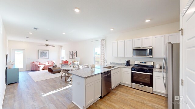 kitchen featuring white cabinets, ceiling fan, kitchen peninsula, and appliances with stainless steel finishes