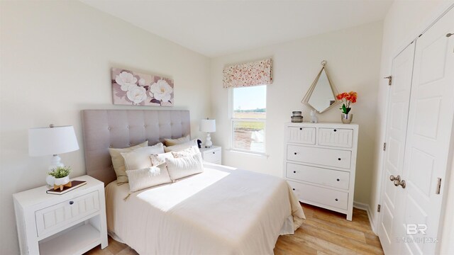 bedroom with light hardwood / wood-style floors and a closet