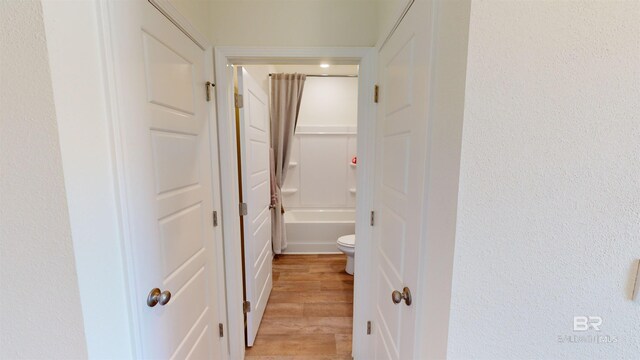 hallway with light hardwood / wood-style floors