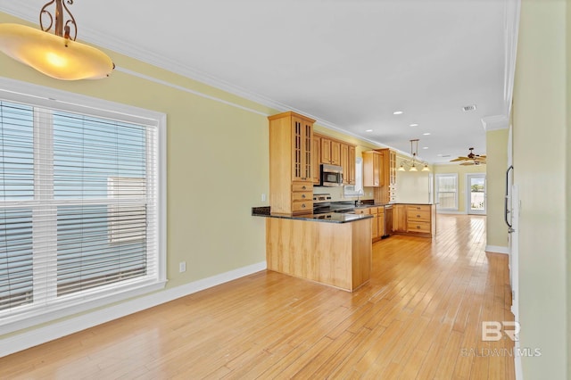 1328 W Lagoon Ave, Gulf Shores, AL 36542 - kitchen featuring a peninsula, stainless steel appliances, ornamental molding, glass insert cabinets, and light wood-style flooring