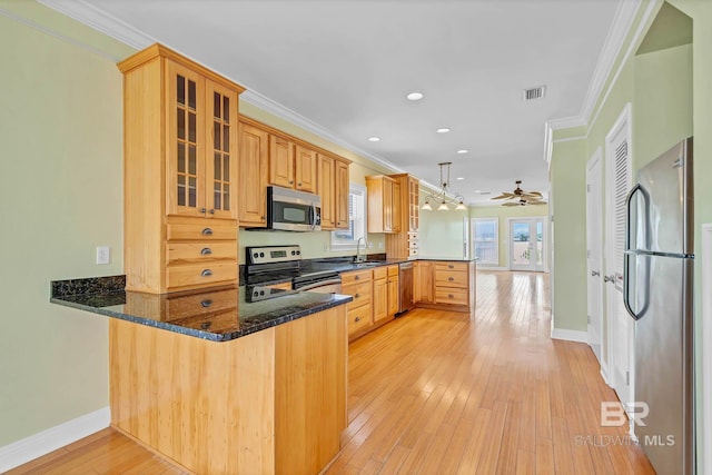 1328 W Lagoon Ave, Gulf Shores, AL 36542 - kitchen featuring appliances with stainless steel finishes, a peninsula, crown molding, ceiling fan, and glass insert cabinets
