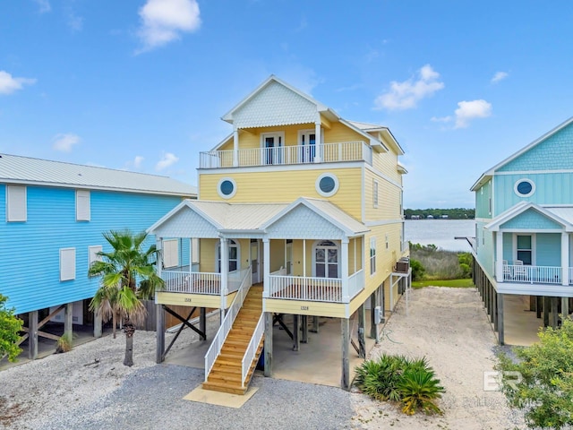 1328 W Lagoon Ave, Gulf Shores, AL 36542 - beach home featuring a carport, a balcony, a porch, stairs, and a water view