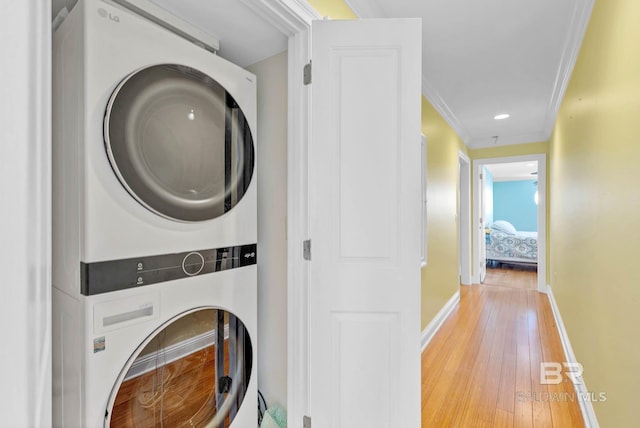 1328 W Lagoon Ave, Gulf Shores, AL 36542 - washroom with stacked washing machine and dryer, light wood-style flooring, crown molding, and recessed lighting