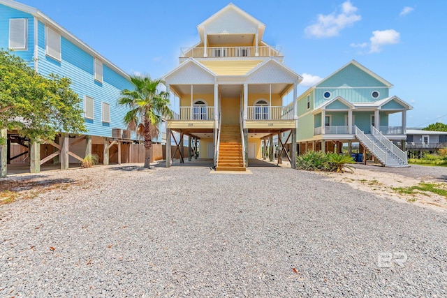 1328 W Lagoon Ave, Gulf Shores, AL 36542 - beach home with stairs, a carport, covered porch, gravel driveway, and a balcony