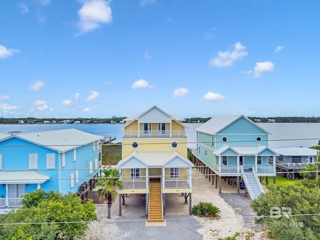 1328 W Lagoon Ave, Gulf Shores, AL 36542 - view of front of house with stairs, a carport, covered porch, driveway, and a balcony
