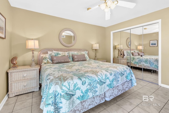 tiled bedroom with ceiling fan, a closet, and baseboards