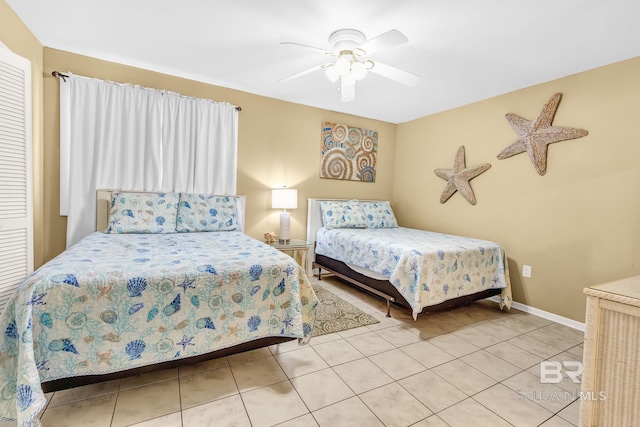 bedroom featuring ceiling fan, baseboards, and light tile patterned floors