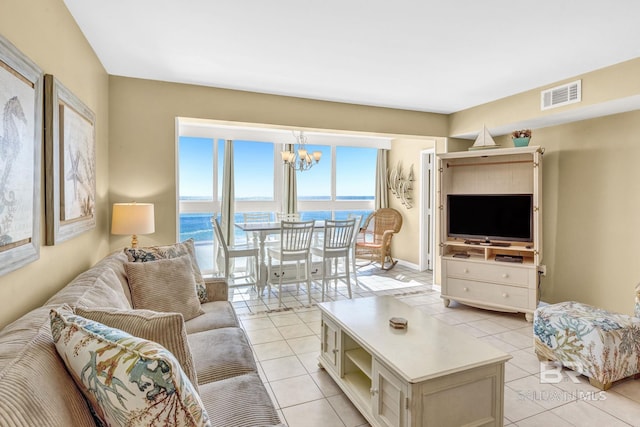 living area featuring light tile patterned floors, a chandelier, and visible vents