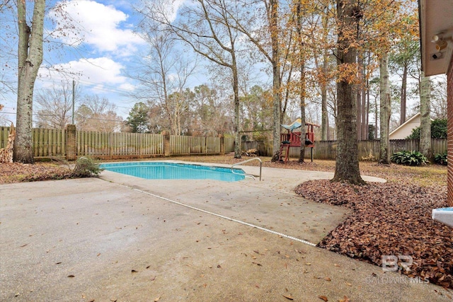 view of pool with a playground and a patio