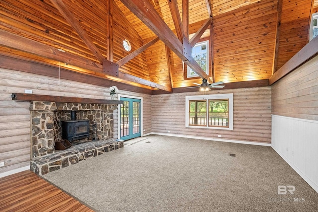 unfurnished living room with wooden ceiling, french doors, a healthy amount of sunlight, and a wood stove