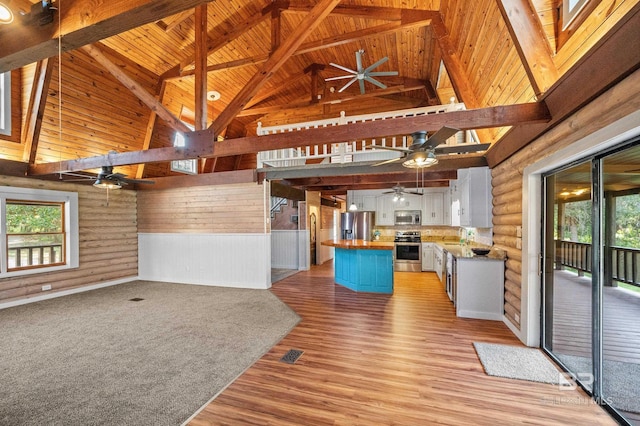 kitchen with wood ceiling, wooden counters, appliances with stainless steel finishes, white cabinets, and a kitchen island