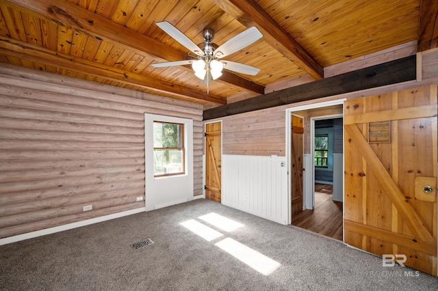 unfurnished bedroom featuring beamed ceiling, dark colored carpet, log walls, and wood ceiling