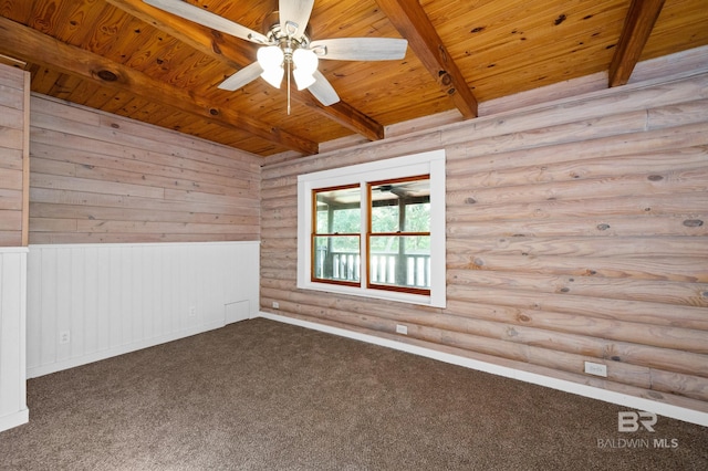 unfurnished room with beamed ceiling, rustic walls, carpet, and wooden ceiling