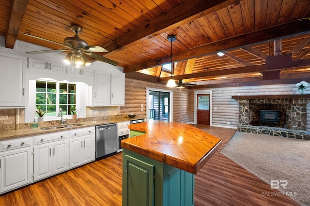 kitchen featuring white cabinetry, stainless steel dishwasher, wooden counters, and a kitchen island