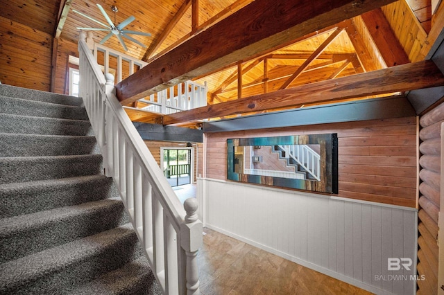 staircase with vaulted ceiling with beams, wood walls, hardwood / wood-style floors, and wooden ceiling