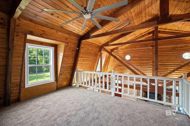 additional living space with wood walls, lofted ceiling with beams, carpet, ceiling fan, and wooden ceiling
