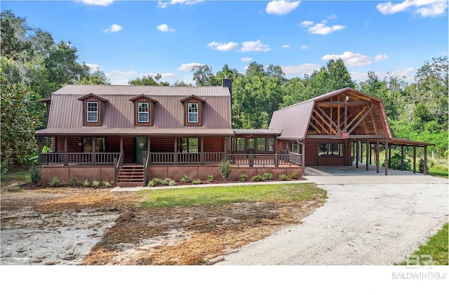 log-style house featuring a carport and covered porch