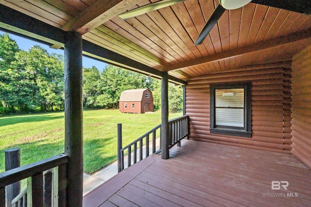 wooden deck featuring a shed, a yard, and ceiling fan
