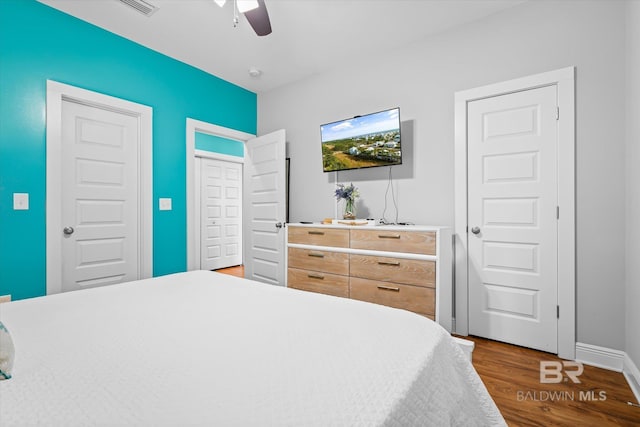 bedroom with ceiling fan, baseboards, and wood finished floors