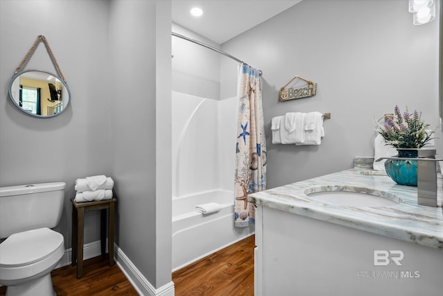 bathroom with toilet, wood finished floors, vanity, baseboards, and shower / bathtub combination with curtain