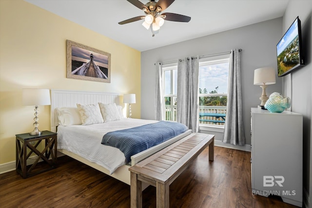 bedroom with ceiling fan, dark wood-style flooring, and baseboards