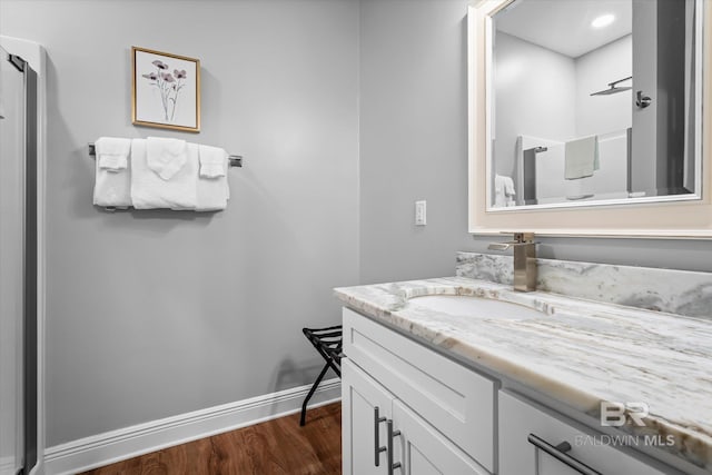 bathroom featuring vanity, baseboards, and wood finished floors