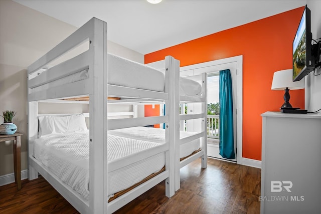 bedroom featuring access to exterior, wood finished floors, and baseboards