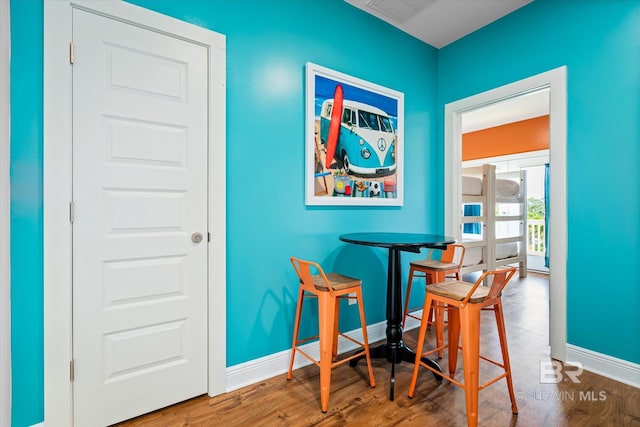 dining area with wood finished floors, visible vents, and baseboards