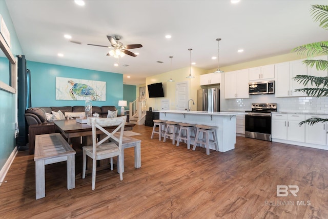 dining space featuring recessed lighting, wood finished floors, a ceiling fan, visible vents, and stairway