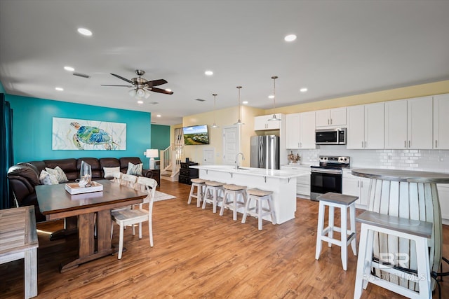 dining space with visible vents, ceiling fan, stairway, light wood-style floors, and recessed lighting