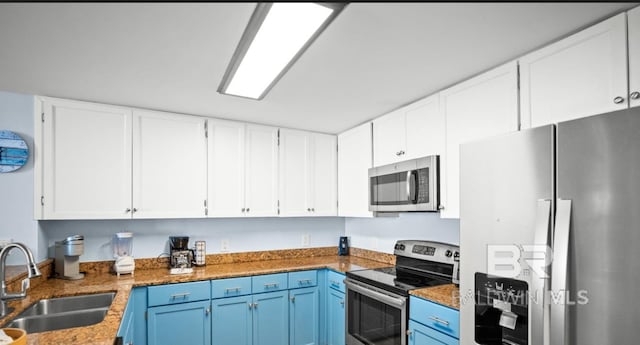 375 Beach Club Trl Unit A1704, Gulf Shores, AL 36542 - kitchen with stainless steel appliances, a sink, blue cabinets, and white cabinetry