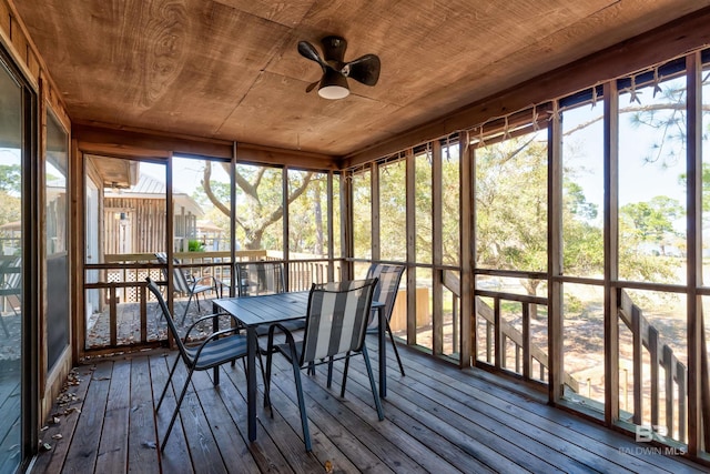 unfurnished sunroom featuring a healthy amount of sunlight, wood ceiling, and a ceiling fan