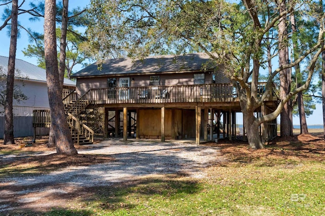 rear view of house with stairs, a carport, driveway, and a wooden deck