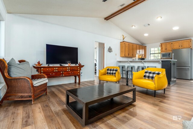 living room with lofted ceiling with beams, visible vents, light wood-style flooring, and recessed lighting