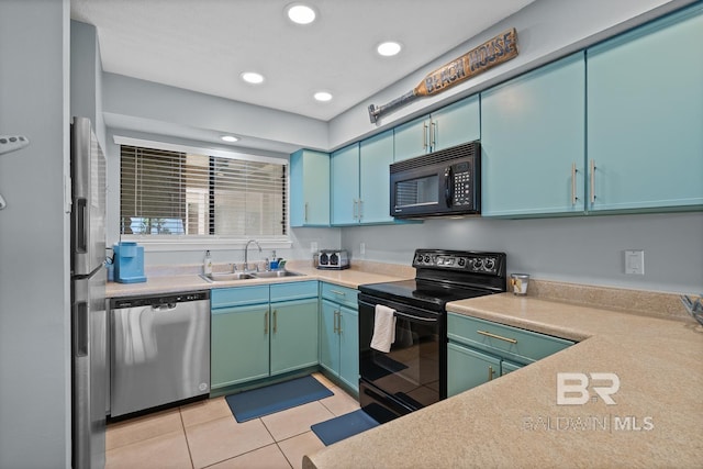 kitchen featuring light countertops, light tile patterned floors, a sink, and black appliances