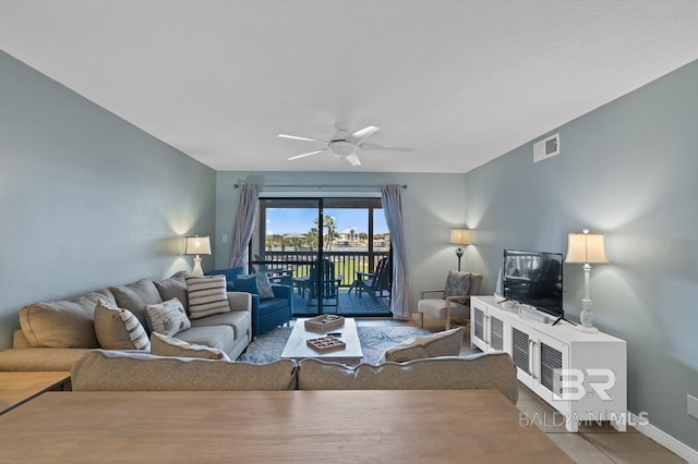 living area featuring visible vents, baseboards, and a ceiling fan