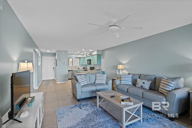 living area featuring light tile patterned floors, baseboards, and a ceiling fan