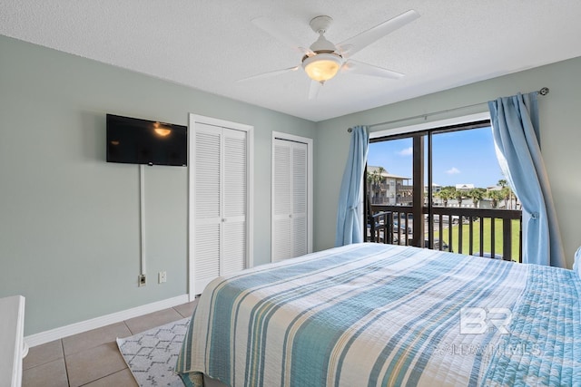 tiled bedroom featuring baseboards, a textured ceiling, access to exterior, multiple closets, and ceiling fan