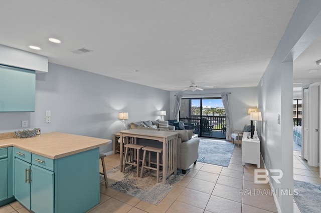 living room featuring light tile patterned flooring, a ceiling fan, visible vents, and recessed lighting
