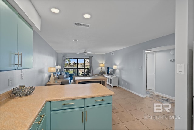 kitchen featuring visible vents, open floor plan, a ceiling fan, a peninsula, and light tile patterned flooring