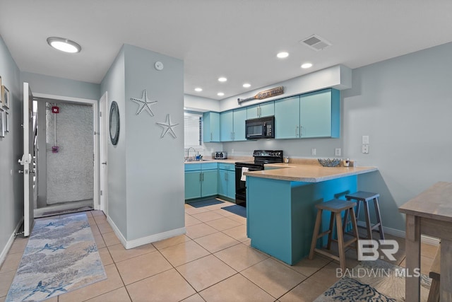 kitchen with blue cabinets, visible vents, a sink, and black appliances